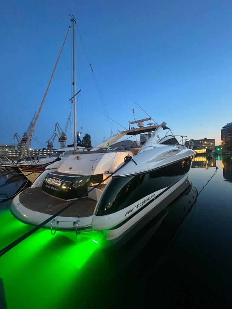 Pokerface moored at dusk with green underwater lights